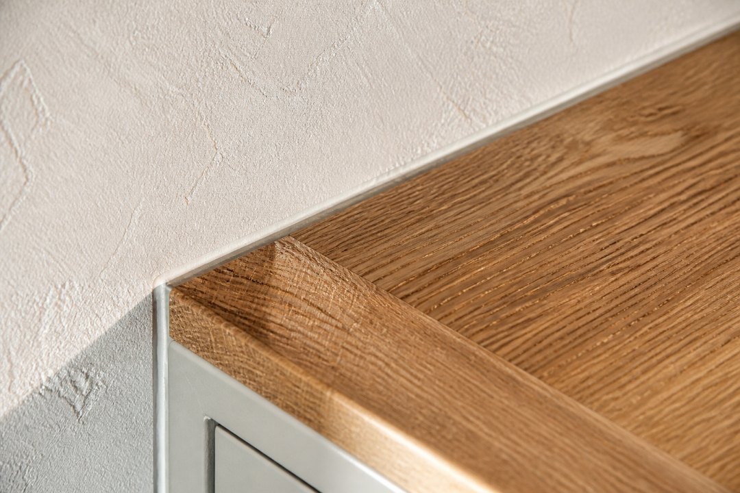 Exempelbild: Detalj: skarven mellan bänkskiva och vägg, snävt utsnitt, sidoljus.